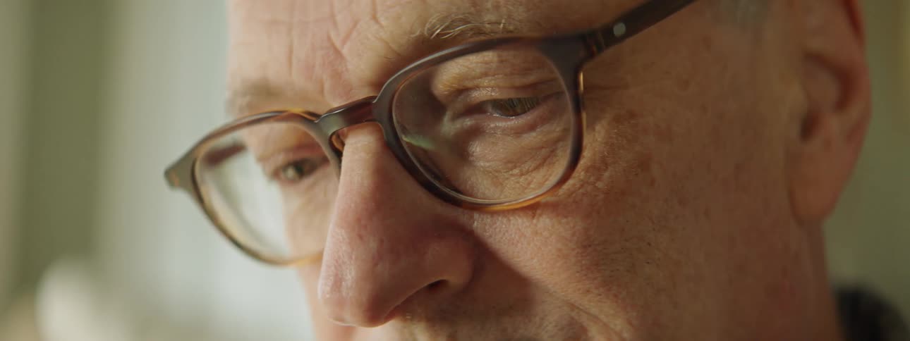 A man is looking around while wearing glasses