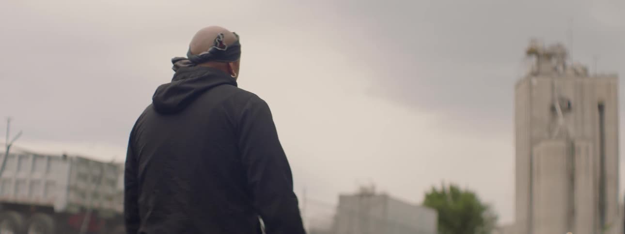 A man wearing a bandana walking outdoor