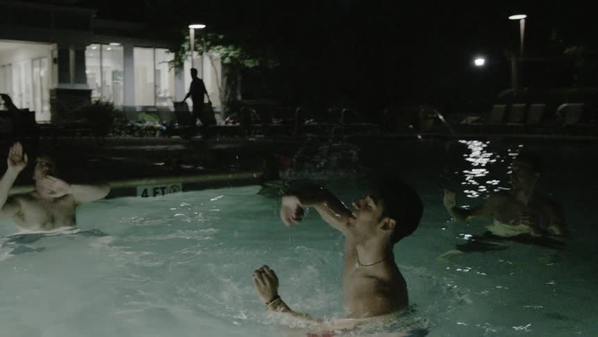 People are in a pool tossing a beach ball