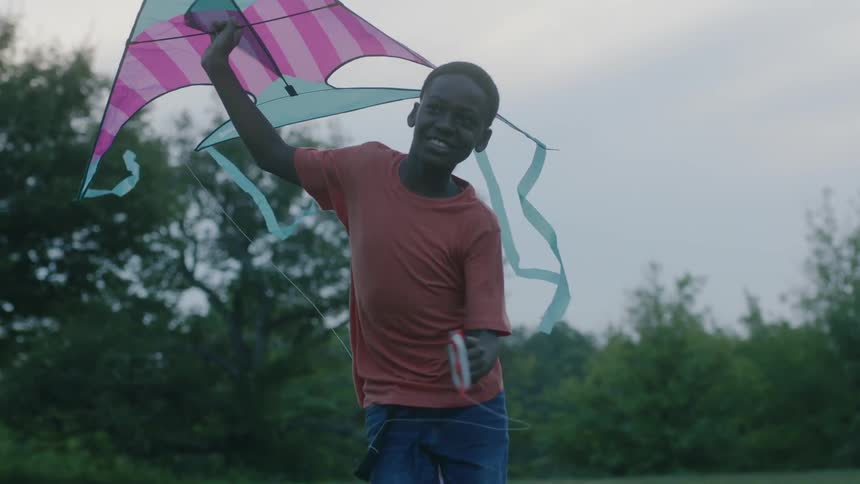 Boy runs with kite in hand