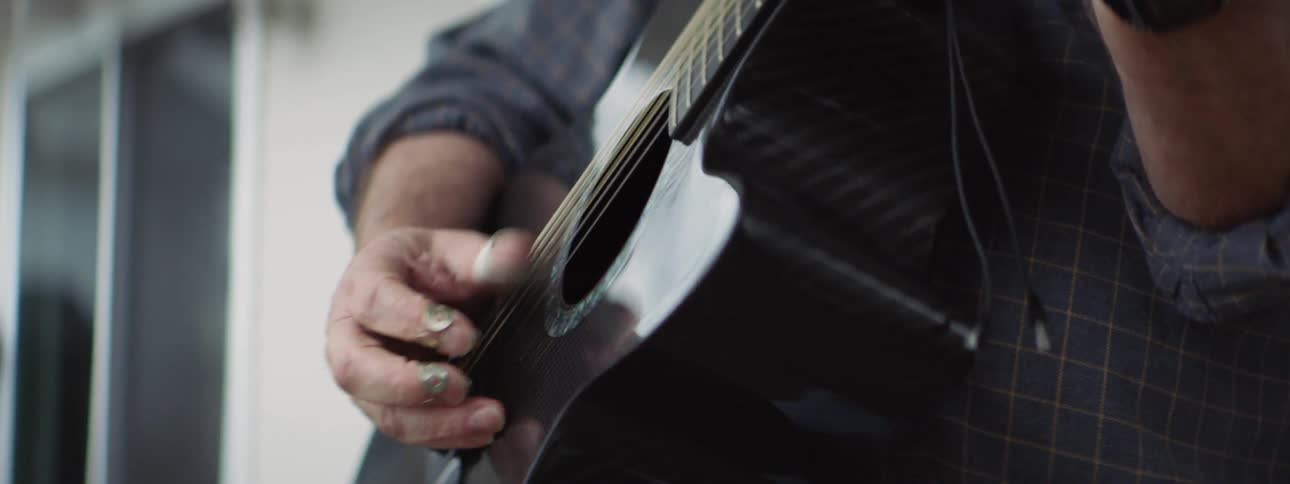 A man is playing guitar indoors