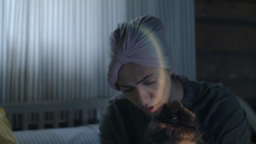 A mother and daughter sitting on a bed