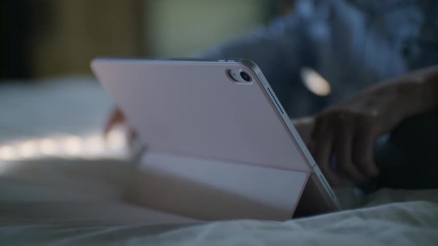 Woman and child use tablet on bed