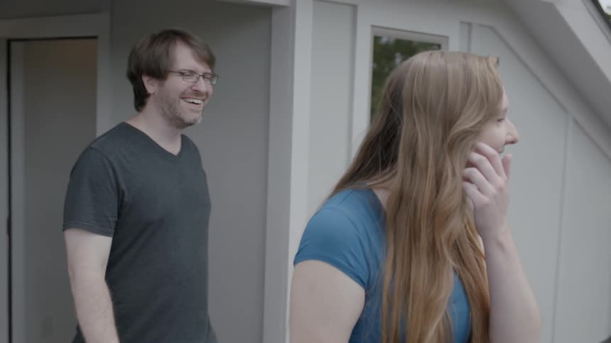A man and woman walk onto a balcony with another man