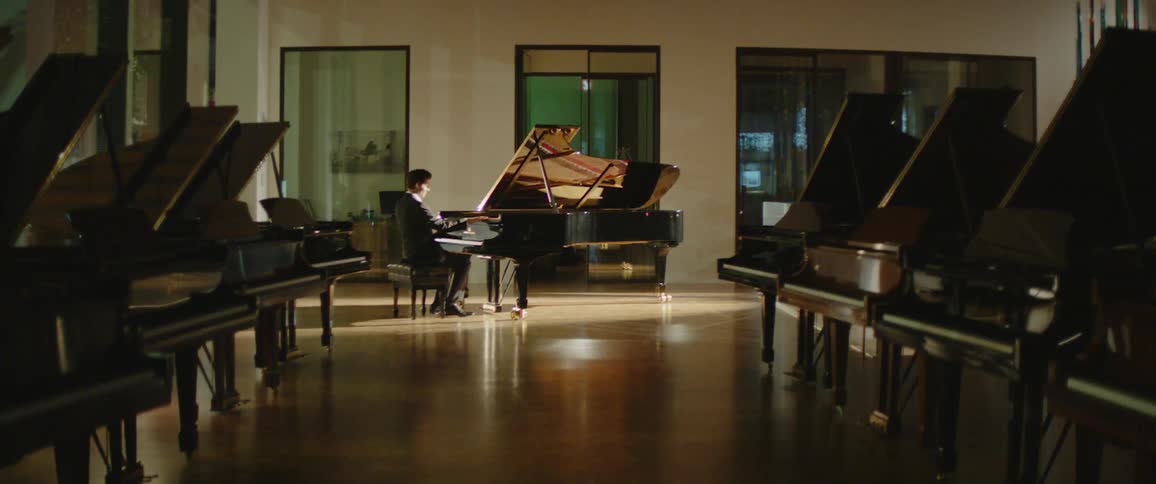 A man sits down at the piano to play