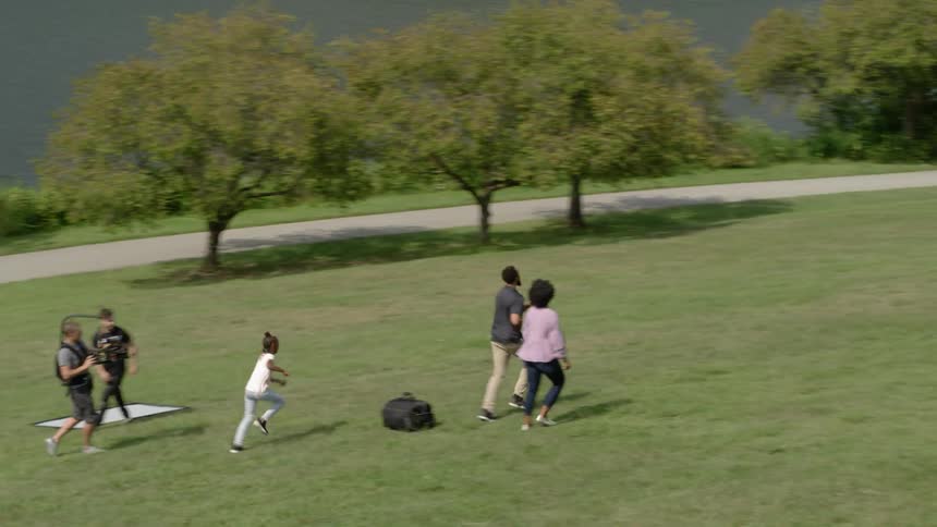 A family runs and plays in a park