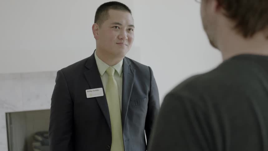 A man smiles and talks with customers