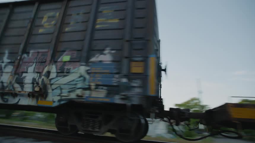 A freight train is traveling down railroad tracks at a fast speed,