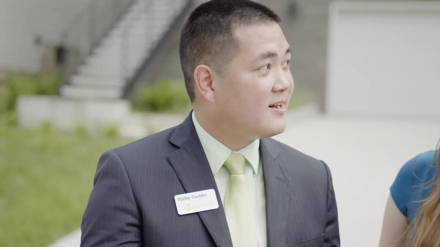 A young couple talks with an older asian man