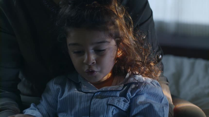 A little girls sits on an adults lap while chatting away