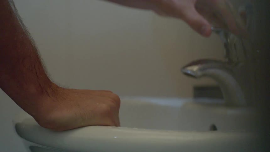 A person holding on to a sink