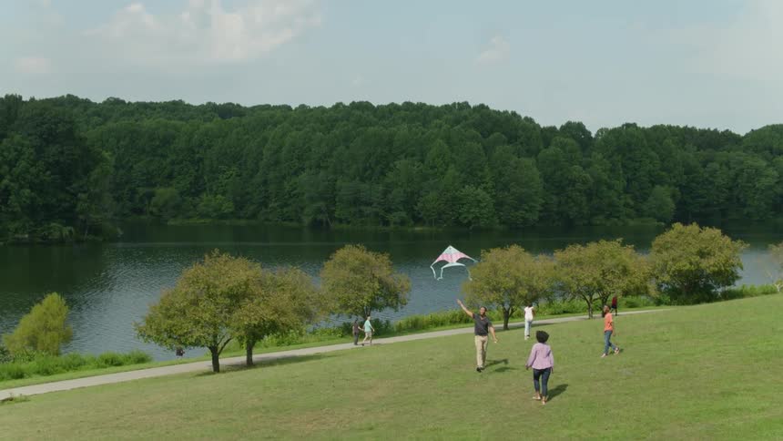 A family fly a kite near the lake