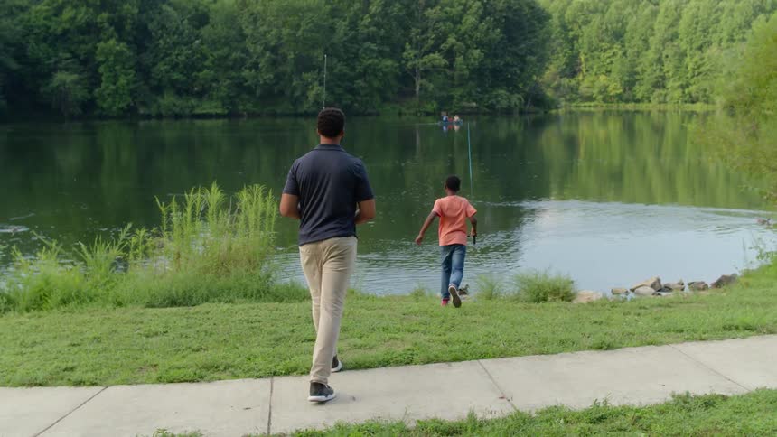 A man and child go fishing in the lake