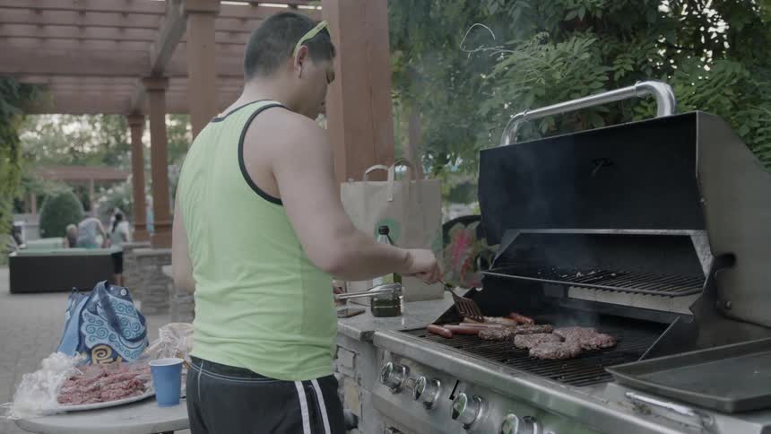 A man is grilling in his backyard