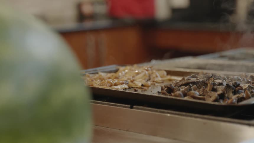 Two types of cooked shredded meat sit on a tray in a kitchen
