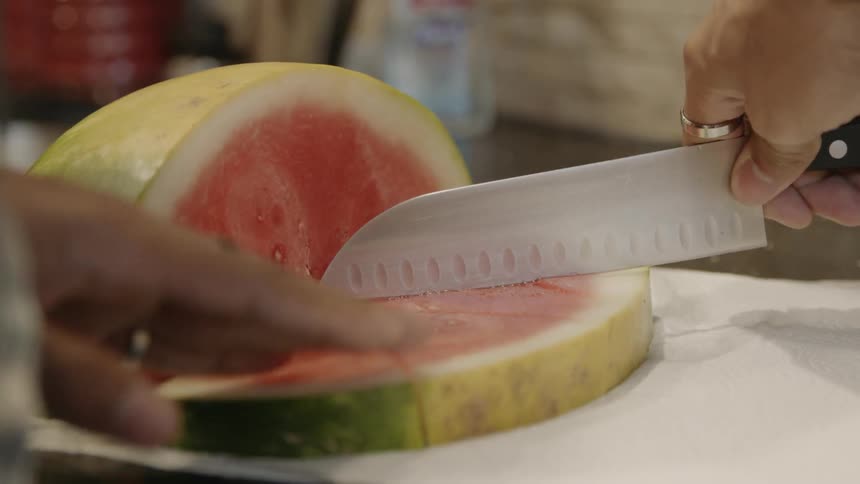 Large wedges of watermelon being cut on a towel