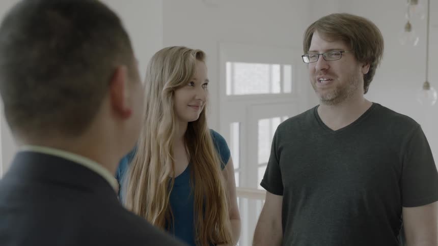 Man talks to a woman and another man in a house