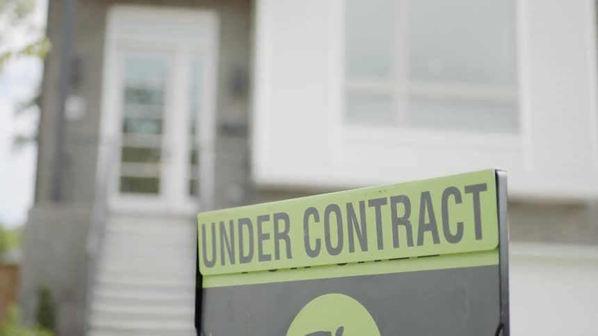 A close up of a sign on a house that says under contract