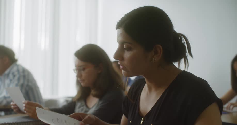 A teacher hands out papers to students in class