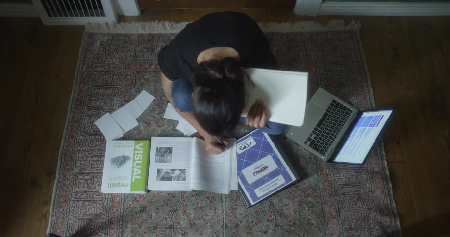 A woman sitting on the floor marking books