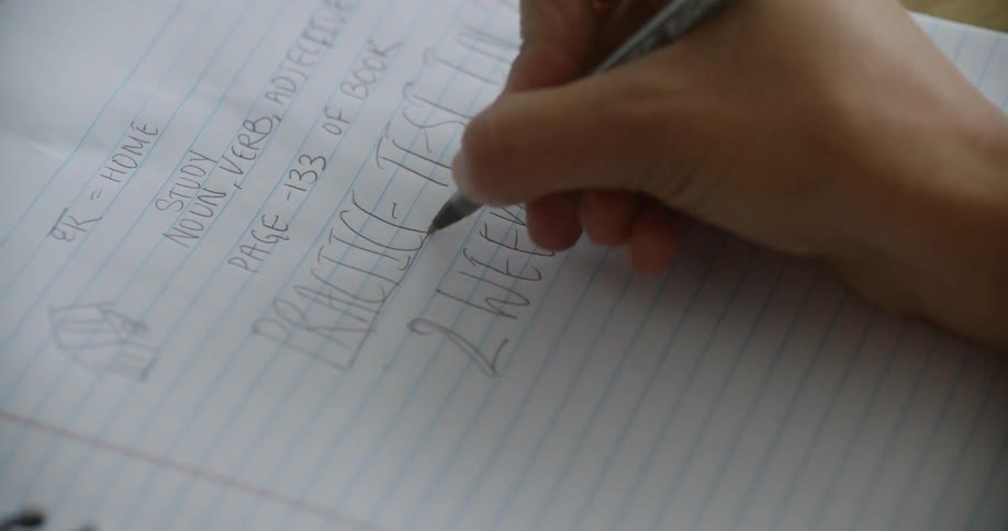 A person is writing on a piece of paper