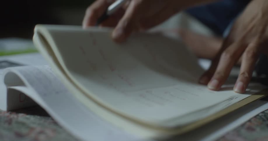 A person taking notes and underlining things in a notebook
