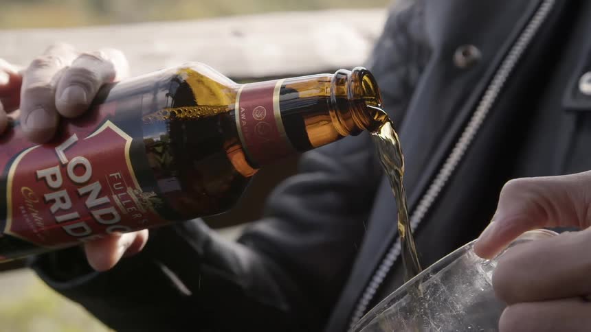 A person pouring a beer