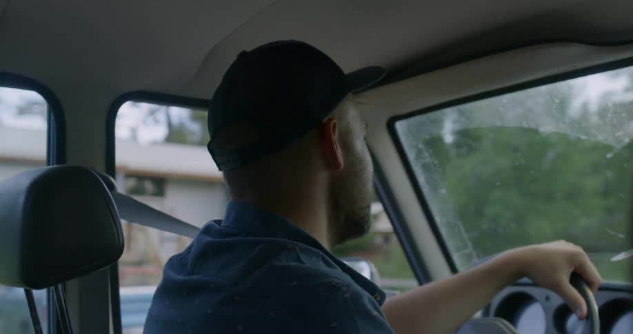 A man driving in a neighborhood