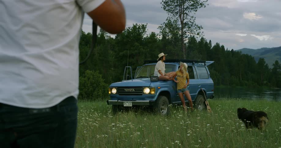 People sitting on a jeep while someone take their picture