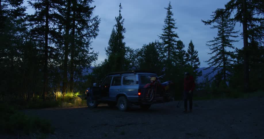 A person is by a car that is parked outdoors