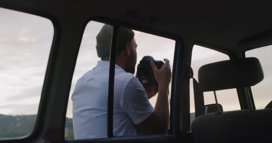 Man taking a photo next to his car