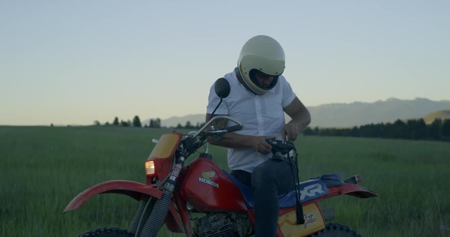 A man is sitting on a motorcycle and taking pictures