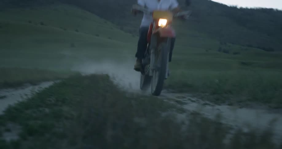 Person drives moped on dirt path