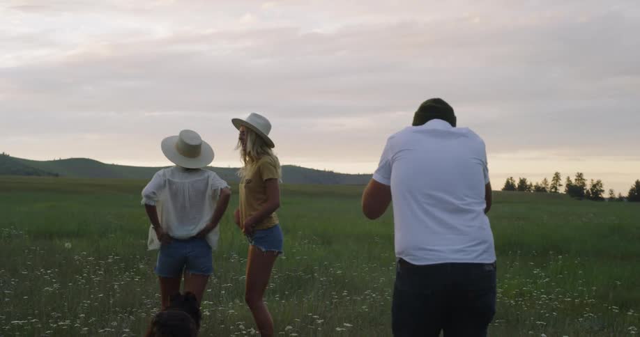 Photographer shooting pictures of two girls and dog on field