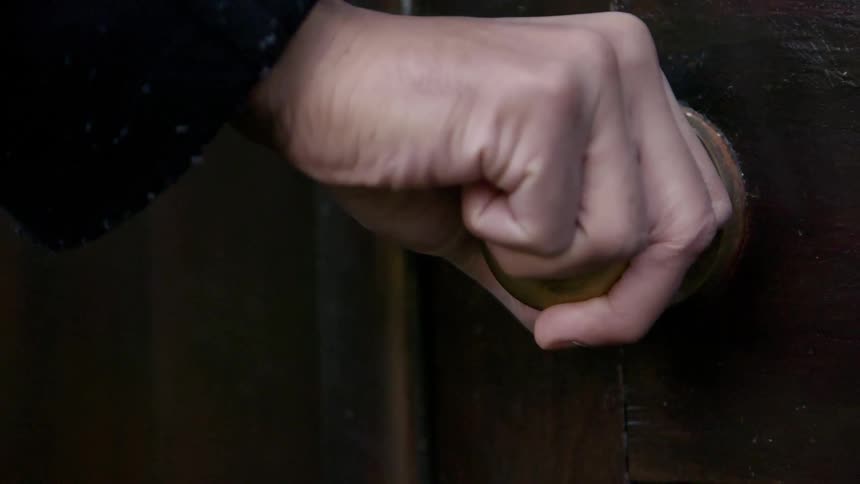 A person turning a door knob
