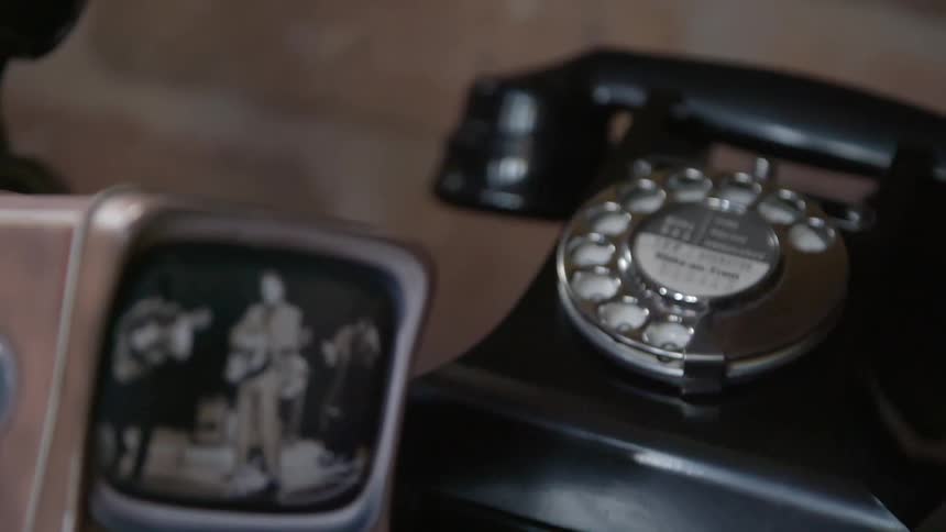A rotary phone and photograph sitting on a table