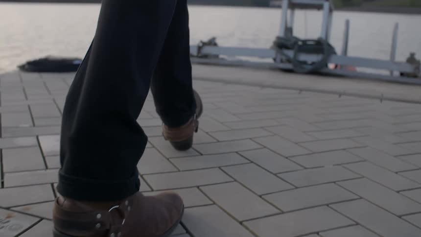 Person walking by the water on a cloudy day