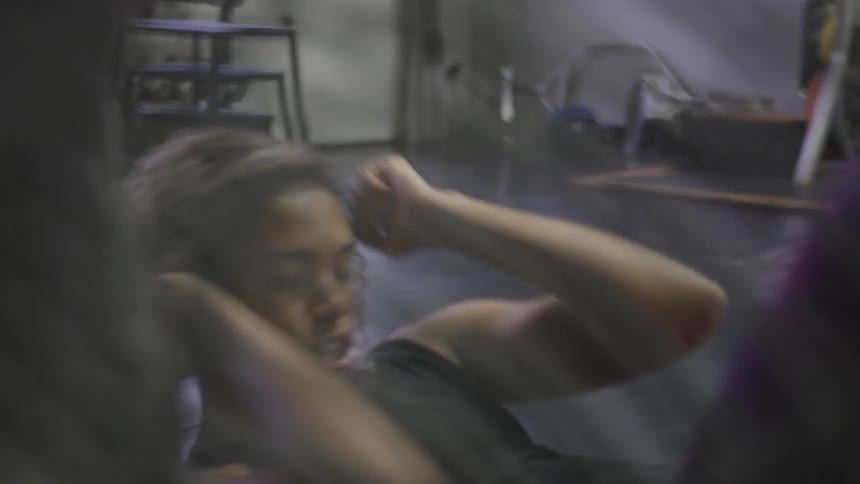 A woman does sit ups in a gym