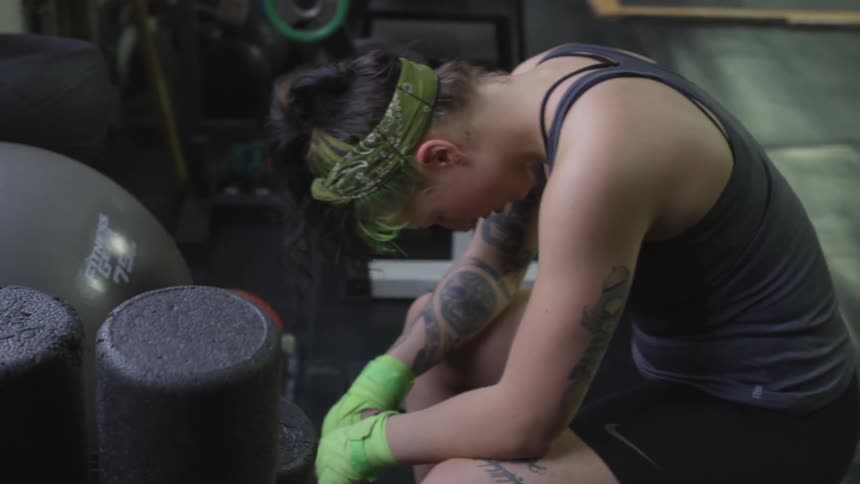 A tattoo covered woman in a fitness studio