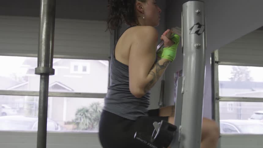 A woman is using work out equipment indoors