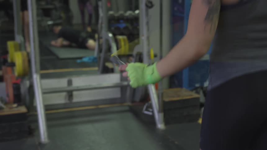 A woman is jumping rope in a gym