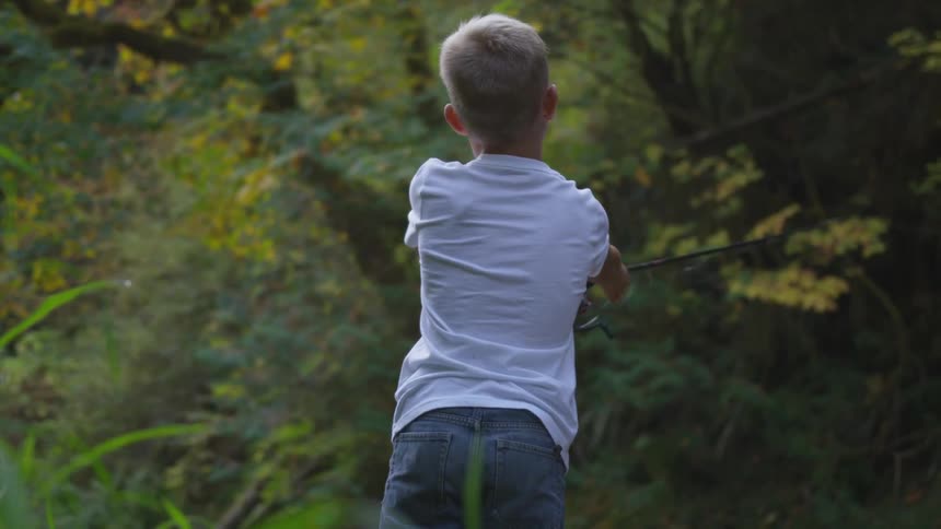 A child is fishing in the forest