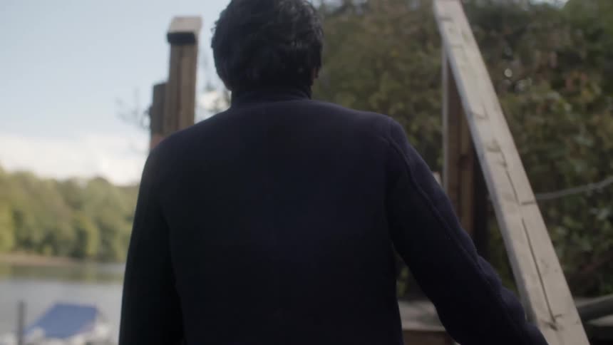 A man walking outside near a lake