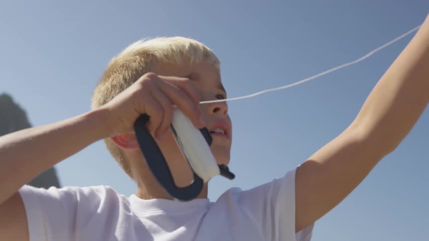 A child is flying a kite on a sunny day