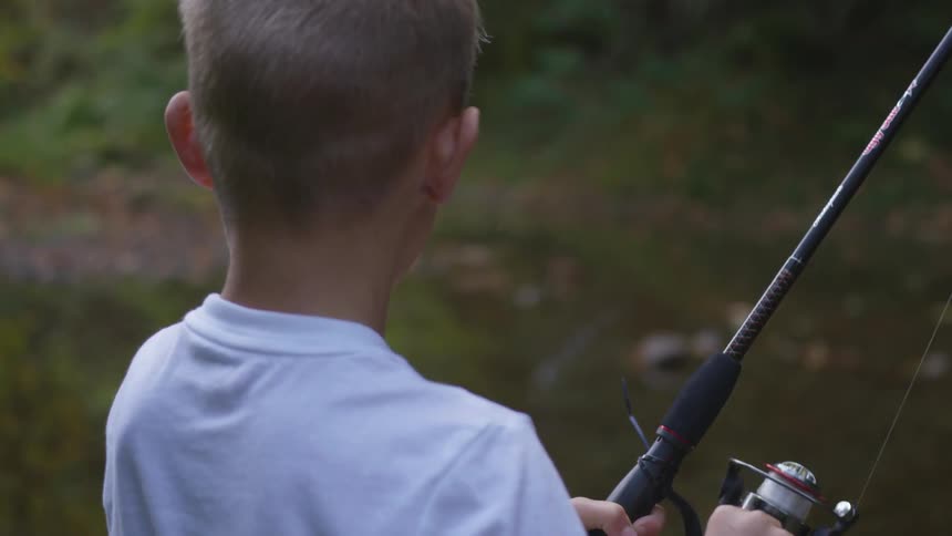 A boy fishing in a small body of water