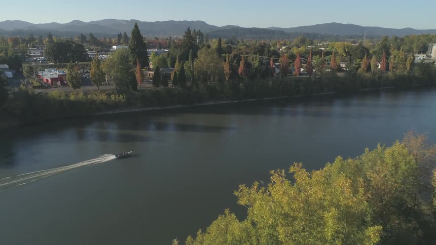 A boat goes down a river late in the day