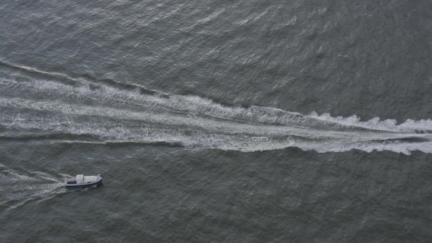 Two boats float on sea on a cloudy day