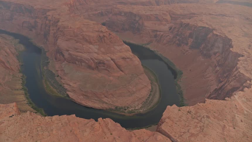 A river flows through a red rock canyon in a desert
