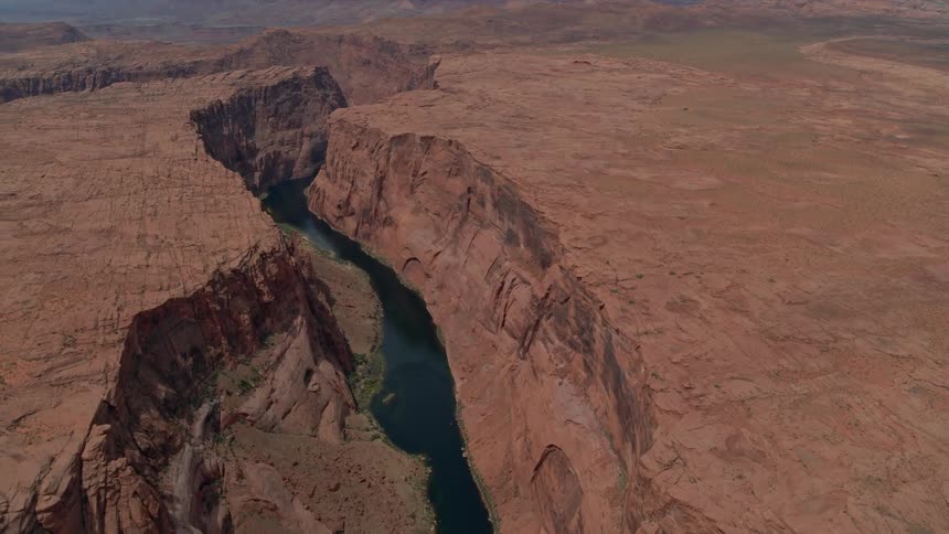 A water source sits in the gaps between arid hills