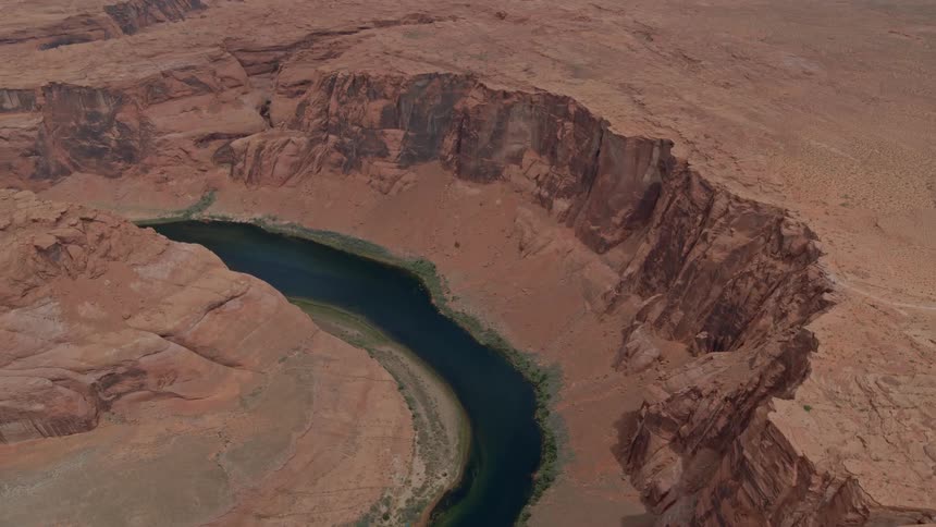 A water source sits in the gaps between arid hills